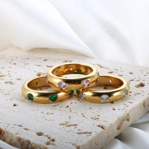 Detaillierte Nahaufnahme von drei 18K Goldringen mit rosa, grünen und klaren Edelsteinen