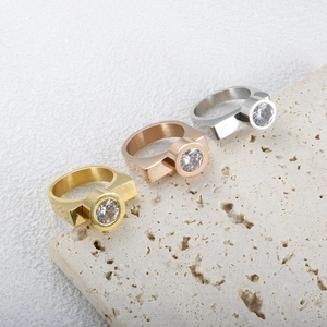Vista dettagliata di tre anelli in acciaio inossidabile oro, oro rosa e argento con zirconi