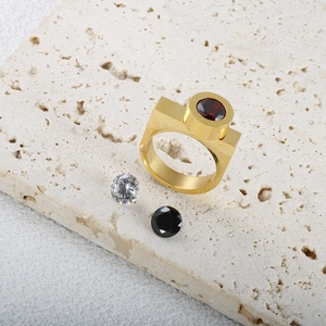 Macro di anello geometrico dorato con pietra rossa intercambiabile su fondo in pietra