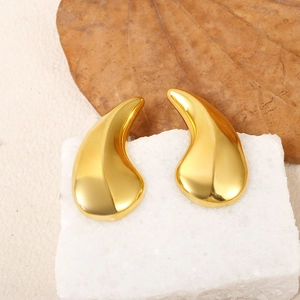 Boucles d'oreilles goutte dorées 18 carats sur un support en pierre minimaliste