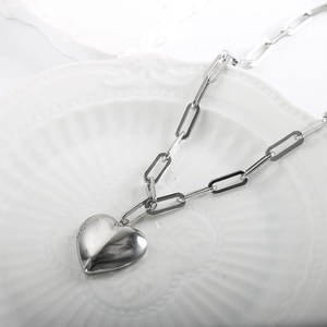 Minimalist silver stainless steel paperclip necklace with a solid heart pendant on a tray