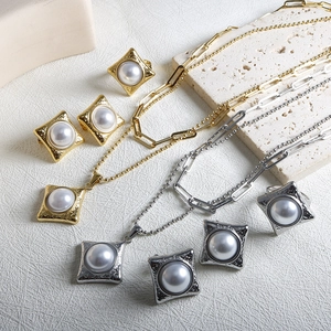 Détail de la base carrée texturée vintage avec perle ronde dans l'ensemble de bijoux