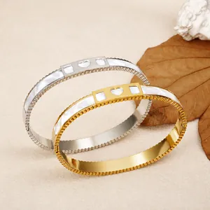 Elegant gold and silver stainless steel bangles with heart motifs and shell inlay