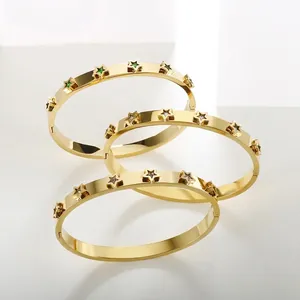 Close-up of 18k gold plated star bracelets with green and white zircon inlays