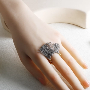Minimalistischer silberner Ketten-Ring mit Goldperlen-Akzenten auf geometrischem Hintergrund