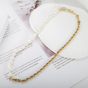 Halskette mit Barockperlen und goldener Gliederkette auf Buchhintergrund im Vintage-Stil