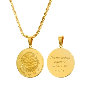 Detailed view of gold twisted chain with engraved round pendant showing shining text