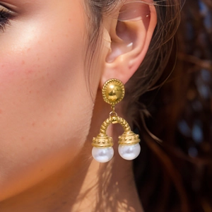 Vue détaillée de boucles d'oreilles vintage en or avec disques et perles blanches
