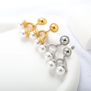 Détail de boucles d'oreilles perles de luxe avec relief en métal doré et argenté
