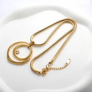Détail du collier chaîne serpent dorée avec double anneaux ovales et zircon étincelant