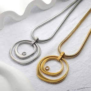 Détail macro de chaînes serpent dorées et argentées avec pendentifs circulaires en cristal