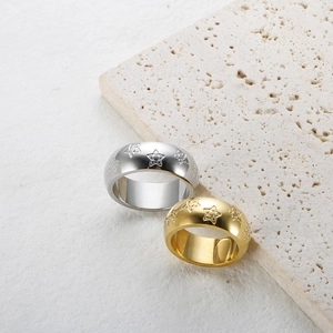 Detalle de los anillos anchos en oro y plata con estrellas sobre piedra natural