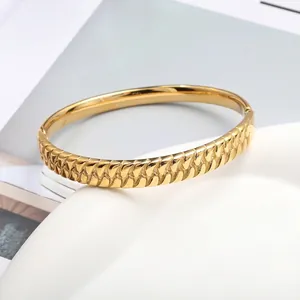 Luxurious gold woven wheat pattern bangle with polished interior and side hinge clasp