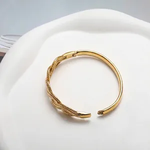 Macro detail of 18K gold plated twisted cable and smooth textures on a sleek bangle
