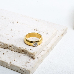 Gros plan d'une bague de luxe en acier titane doré avec un oxyde de zirconium brillant