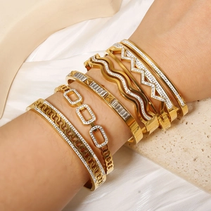 Stackable gold-plated hollow square bracelets with sparkling crystals on white silk