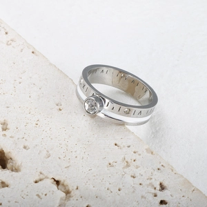 Macro view of Roman numerals ring with white ceramic inlay and sparkling zircon stone