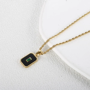 Nahaufnahme der 18K Goldseilkette mit einem Vintage-Anhänger mit grünem Zirkon