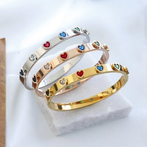 Detailed view of luxury heart-shaped crystal bangles in silver, rose gold and gold finishes