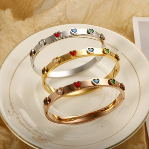 Three-color heart gemstone inlaid stainless steel bracelets on white ceramic plate