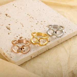 Close-up of three titanium steel rings in rose gold, gold, and silver with zircon accents