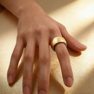 Bague large en acier inoxydable doré poli portée au doigt avec bords texturés