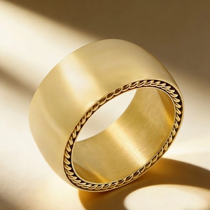 Bague large en acier inoxydable doré avec texture brossée et bords tressés