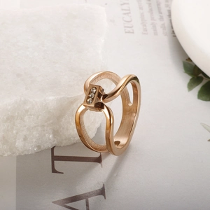 Detail of rose gold geometric titanium ring with micro-set stones on textured stone