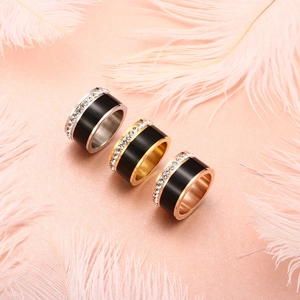 Drie minimalistische titanium stalen ringen met zwart emaille en zirkoon op roze veren