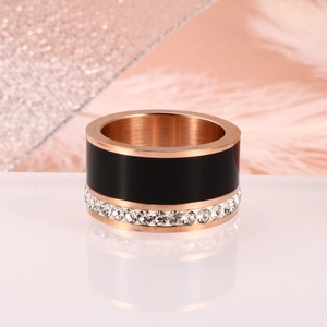Macro-opname van roségouden ring met zwart emaille en een rand van witte kristallen