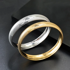 Bracciali in oro 18 carati e argento con trama a nido d'ape su sfondo nero profondo