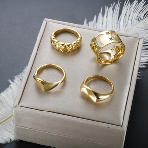 Close-up of four-piece vintage gold stackable ring set with moon star and wave patterns