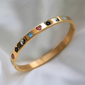Macro view of gold bracelet featuring colorful Tai Chi stars and heart enamel designs
