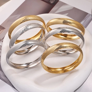 Vista dettagliata del set di 6 bracciali rigidi oro e argento con varie trame a rilievo