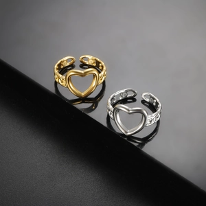 Detailopname van hartvormige open ringen in goud en zilver met kettingstructuur en magneten