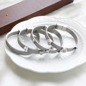 Detail von silbernen Mesh-Armbändern mit Zirkon-Herz und römischen Ziffern-Anhängern