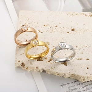 Dettaglio di anelli a cuore lucidati con zirconi in oro rosa, oro e colore argento