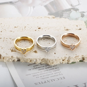 Dettaglio di anelli a cuore in oro, argento e oro rosa con tre pietre di zircone