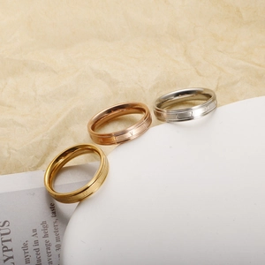 Macro detail of roman numerals engraved on a stack of three-tone titanium rings