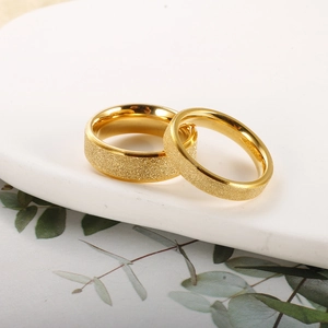 Detailed macro view of matte frosted gold stainless steel rings on a white plate