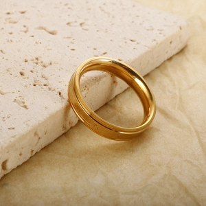 Macro shot of rose gold titanium ring with engraved Roman numerals on stone background