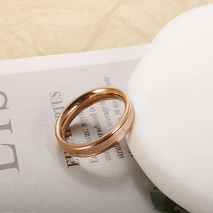 Detail of rose gold titanium steel ring with roman numerals and polished mirror finish