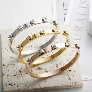 Detailed view of three stackable flower bangle bracelets in silver gold and rose gold