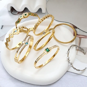 Detail von vergoldeten und versilberten Armbändern mit Smaragd- und Zirkonia-Inlays auf Keramik
