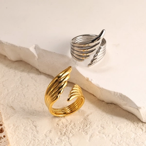 Close-up of creative feather-shaped spiral open rings in gold and silver finishes