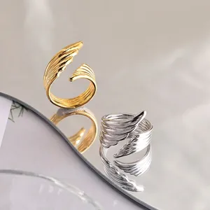 Detailed view of gold and silver angel wing open rings with polished feather textures