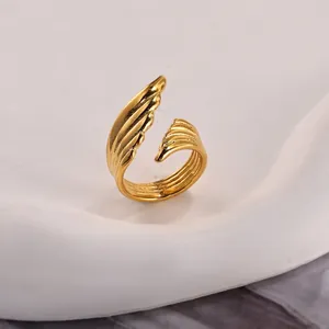 Detailed macro view of gold angel wing ring with intricate feather textures and open band