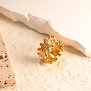 Detailed macro view of gold wide band ring with hammered texture and beaded edge
