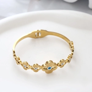 Makro-Detail des vergoldeten Evil Eye Armreifs mit Emaille und Sonnenstrahl-Textur