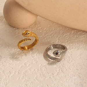 Detail of snake scale texture and crystal accents on gold and silver wrap rings